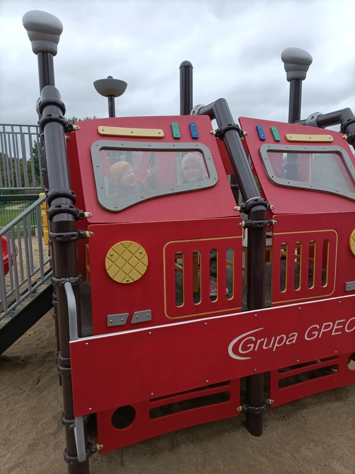 Children playing in the red train structure at Reagan Park playground